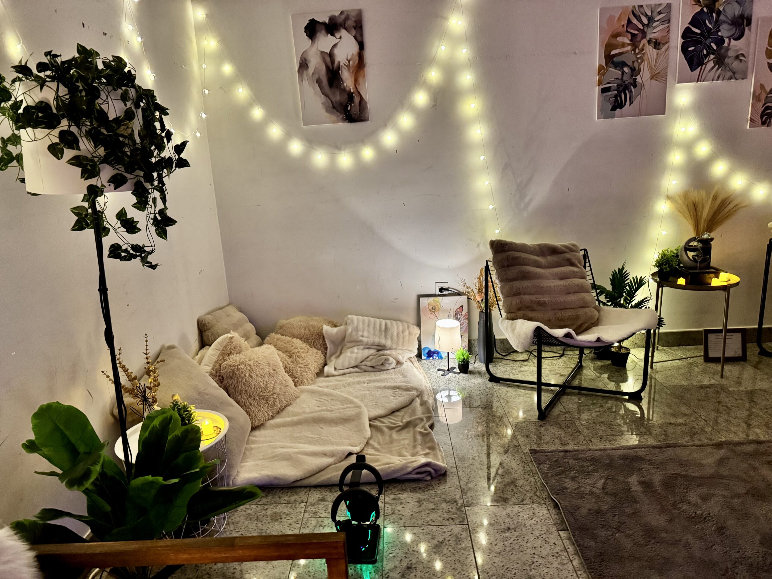 Floor pillows, plants, lanterns, and chairs with fairy lights in Calm Nest wellbeing nook