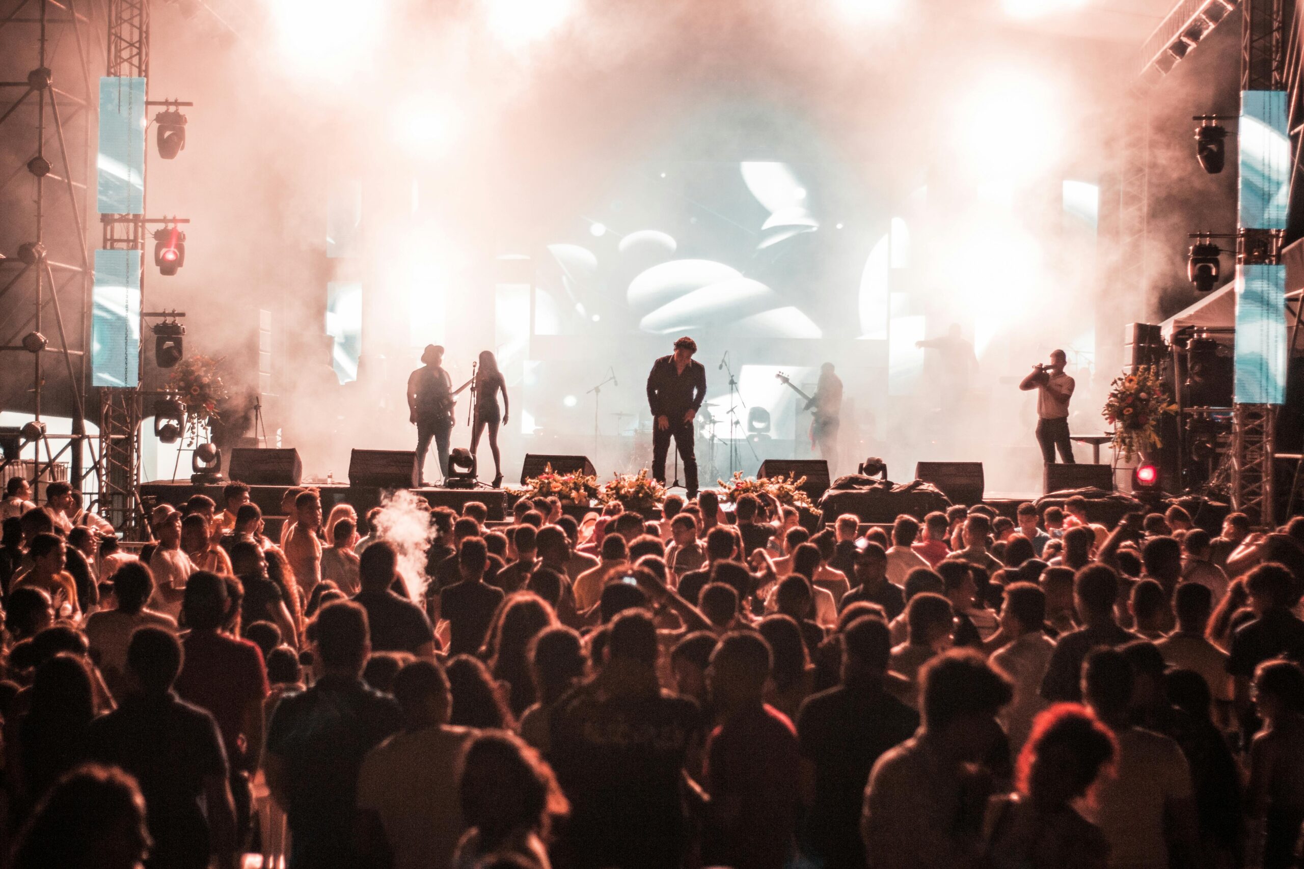 A large outdoor music festival with a packed crowd and bright stage lights, highlighting the importance of sensory-friendly design and calm spaces at large-scale events